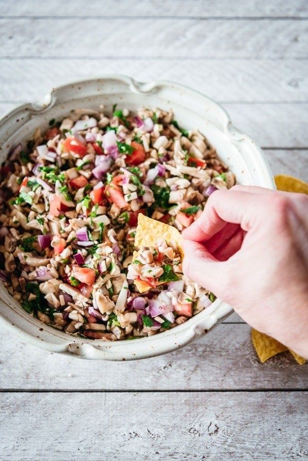 Ceviche de champiñones con una tortilla chip.
