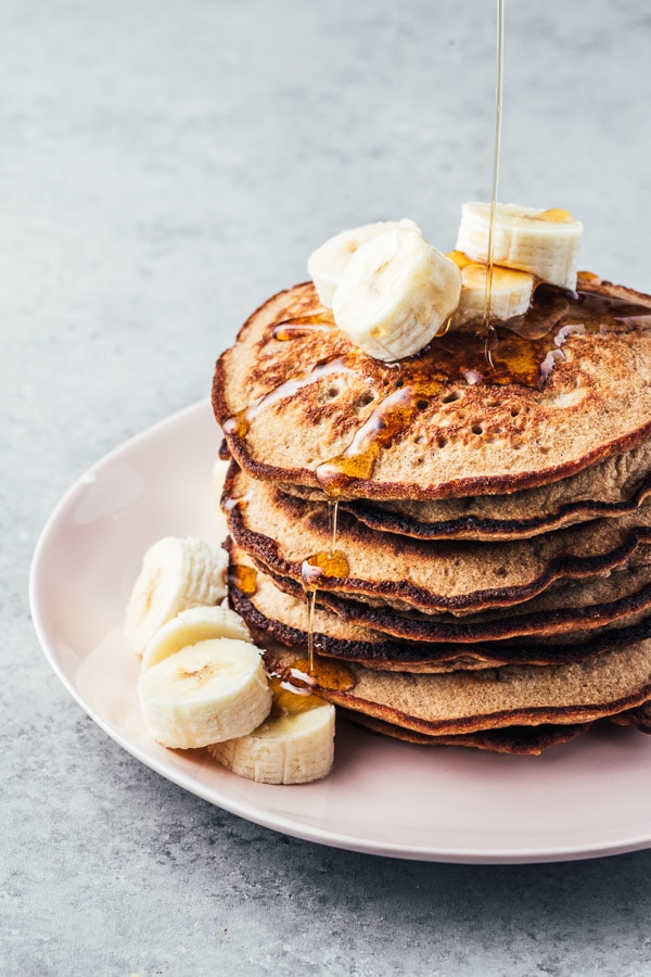 Panqueques de banana verde sin gluten derramando el sirope.