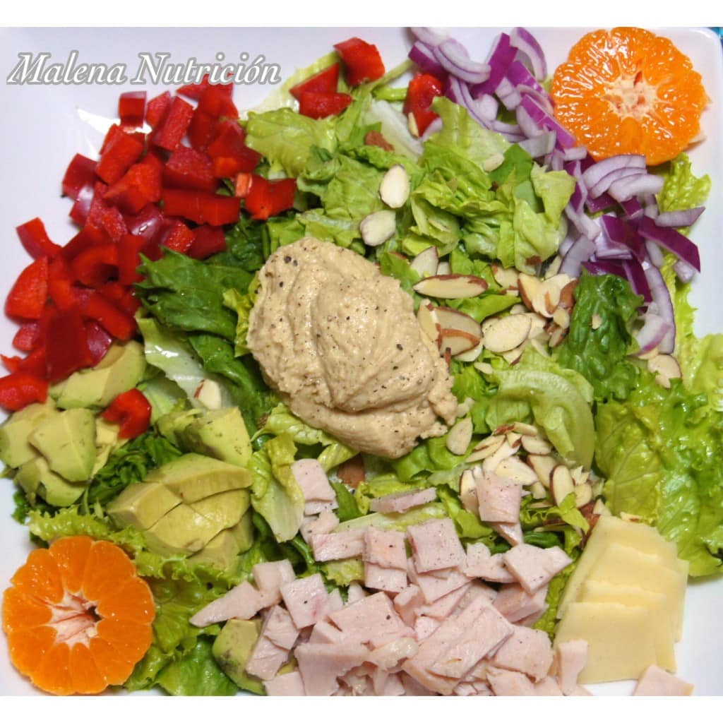 Ensalada completa de lechuga, naranja, pimiento rojo, aguacate, pimiento rojo, jamón, almendras y cebolla.