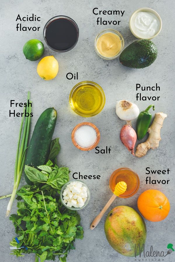 Ingredients for salad dressings: mustard, avocado, greek yogurt, garlic, onion, jalapeño, mango, orange, honey, fresh herbs, cheese, oil, salt, lime, lemon, and balsamic vinegar.
